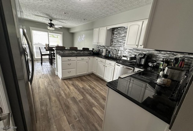 324 Buttermere Ln, Amherst, OH 44001 - kitchen featuring stainless steel appliances, a peninsula, ceiling fan, white cabinets, and backsplash