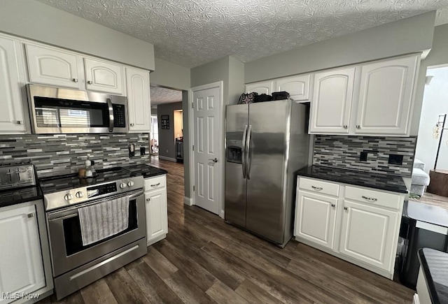 324 Buttermere Ln, Amherst, OH 44001 - kitchen with stainless steel appliances, dark countertops, white cabinetry, dark wood-type flooring, and a textured ceiling