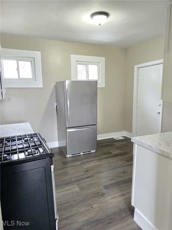 4175 E 95th St, Cleveland, OH 44105 - kitchen featuring freestanding refrigerator, range with gas cooktop, dark wood-style floors, and light stone countertops