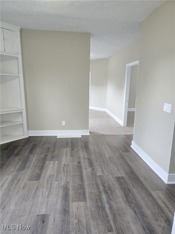 4175 E 95th St, Cleveland, OH 44105 - unfurnished room with dark wood-type flooring, built in features, and a textured ceiling