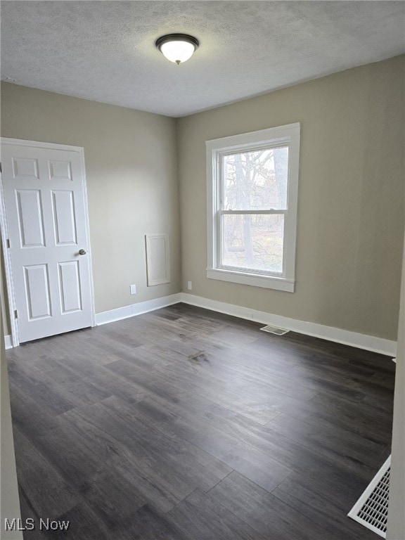 4175 E 95th St, Cleveland, OH 44105 - unfurnished room featuring dark wood-style flooring and a textured ceiling