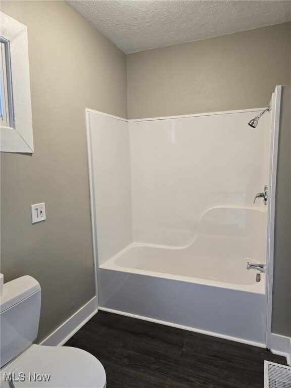 4175 E 95th St, Cleveland, OH 44105 - bathroom with wood finished floors, bathtub / shower combination, and a textured ceiling