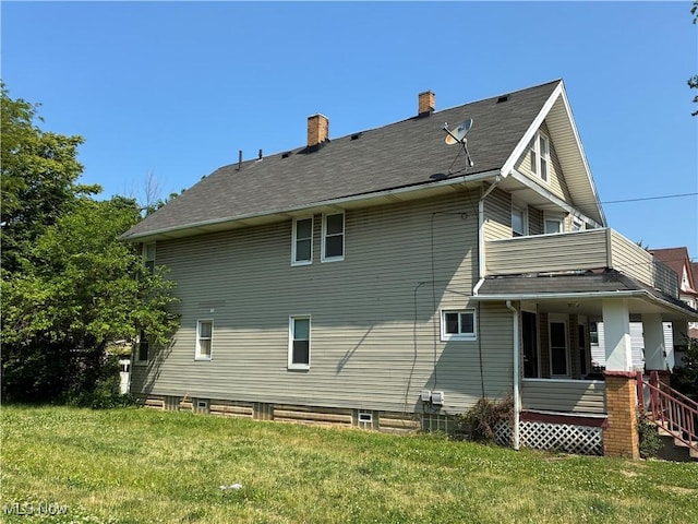 2032 W 98th St, Cleveland, OH 44102 - back of house featuring a balcony, a chimney, and a lawn