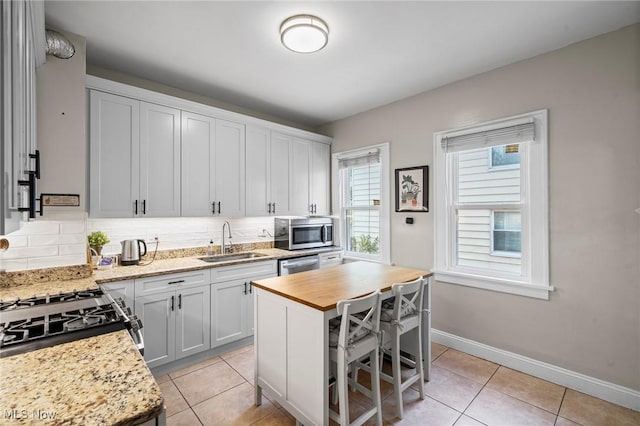 1646 Wyandotte Ave, Lakewood, OH 44107 - kitchen featuring appliances with stainless steel finishes, light tile patterned floors, tasteful backsplash, and butcher block counters