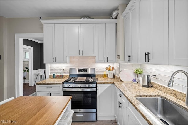 1646 Wyandotte Ave, Lakewood, OH 44107 - kitchen with stainless steel range with gas cooktop, white cabinetry, decorative backsplash, and light stone counters