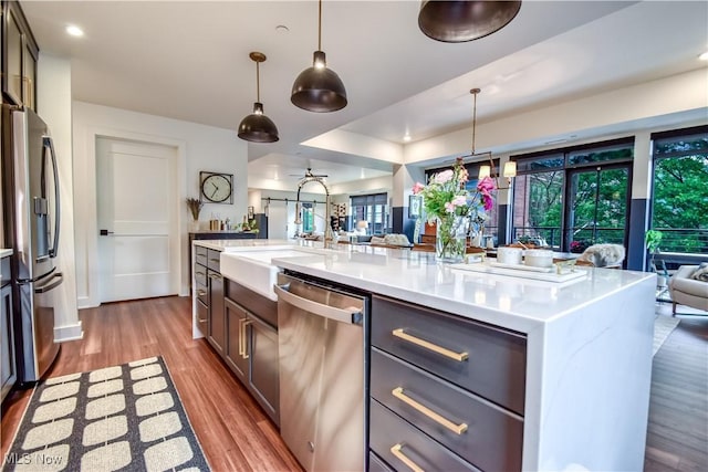 2044 Random Rd Unit 303, Cleveland, OH 44106 - kitchen with appliances with stainless steel finishes, open floor plan, wood finished floors, light countertops, and plenty of natural light