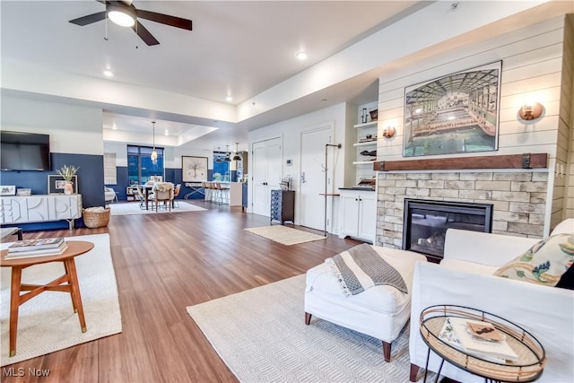 2044 Random Rd Unit 303, Cleveland, OH 44106 - living area with wood finished floors, ceiling fan, a stone fireplace, and recessed lighting