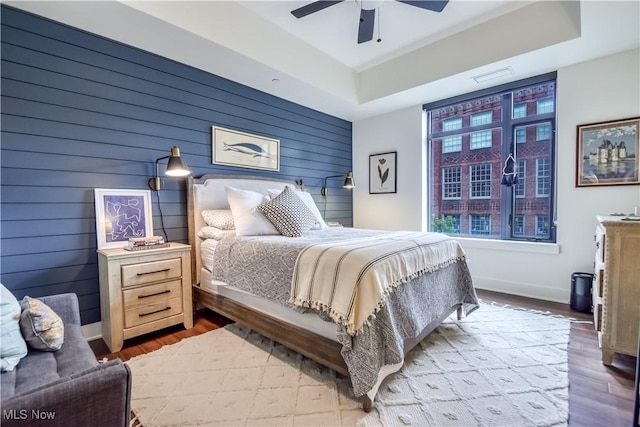 2044 Random Rd Unit 303, Cleveland, OH 44106 - bedroom with a tray ceiling, wood finished floors, wooden walls, and ceiling fan