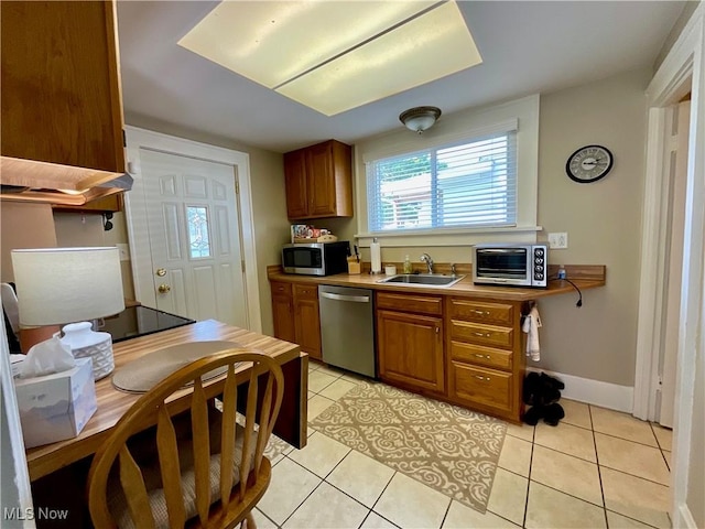 904 Chalker St, Akron, OH 44310 - kitchen with appliances with stainless steel finishes, brown cabinetry, light tile patterned floors, and light countertops