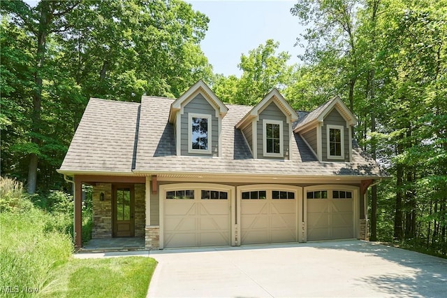 3116 Aviemore Way, Richfield, OH 44286 - view of front facade featuring concrete driveway, stone siding, a garage, and roof with shingles