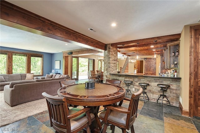 3116 Aviemore Way, Richfield, OH 44286 - dining space with stone tile floors, beamed ceiling, bar area, decorative columns, and recessed lighting