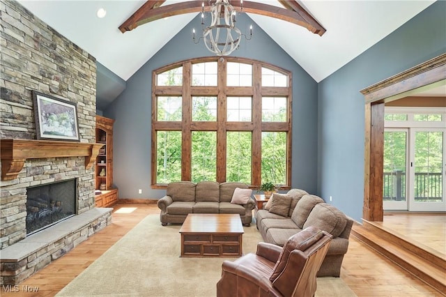 3116 Aviemore Way, Richfield, OH 44286 - living room featuring high vaulted ceiling, wood finished floors, a chandelier, a stone fireplace, and beam ceiling