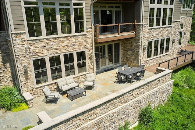 3116 Aviemore Way, Richfield, OH 44286 - back of house with stone siding, a patio area, a balcony, and french doors