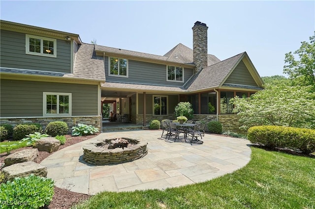 3116 Aviemore Way, Richfield, OH 44286 - back of house featuring a patio, a fire pit, stone siding, and a chimney