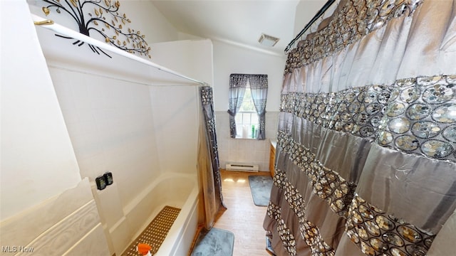 217 Meadowbrook Ave, Boardman, OH 44512 - full bath with a baseboard heating unit, wood finished floors, tile walls, shower / bathtub combination with curtain, and lofted ceiling