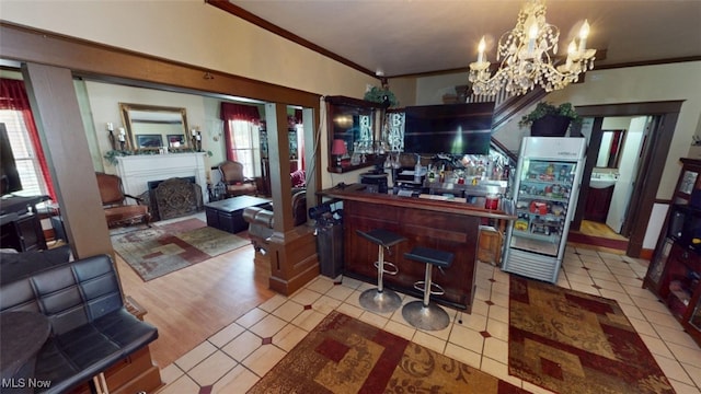 217 Meadowbrook Ave, Boardman, OH 44512 - indoor bar with crown molding, a chandelier, a fireplace, and freestanding refrigerator
