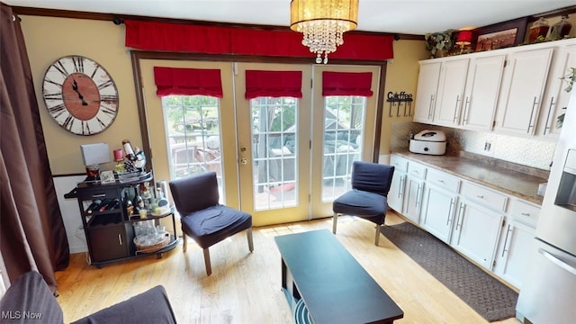 217 Meadowbrook Ave, Boardman, OH 44512 - living area with light wood-style flooring, a chandelier, french doors, and ornamental molding