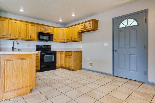 1104 4th St, Belpre, OH 45714 - kitchen with black appliances, light countertops, tasteful backsplash, brown cabinets, and light tile patterned flooring