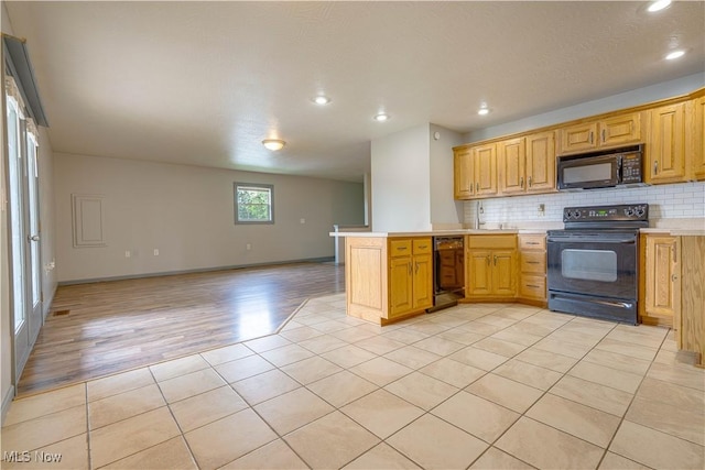 1104 4th St, Belpre, OH 45714 - kitchen with black appliances, a peninsula, open floor plan, light tile patterned floors, and light countertops