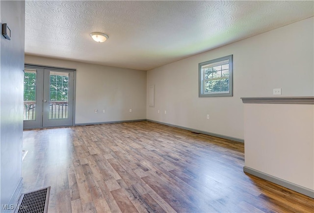 1104 4th St, Belpre, OH 45714 - empty room with wood finished floors, french doors, and a textured ceiling