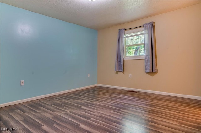 1104 4th St, Belpre, OH 45714 - spare room featuring dark wood-style flooring and a textured ceiling