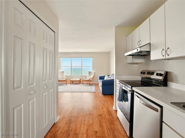 5237 Lake Rd W Unit 1133, Ashtabula, OH 44004 - kitchen with appliances with stainless steel finishes, under cabinet range hood, light wood finished floors, light countertops, and white cabinetry