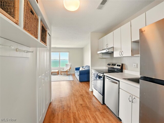 5237 Lake Rd W Unit 1133, Ashtabula, OH 44004 - kitchen with stainless steel appliances, under cabinet range hood, light wood-style floors, white cabinets, and light countertops