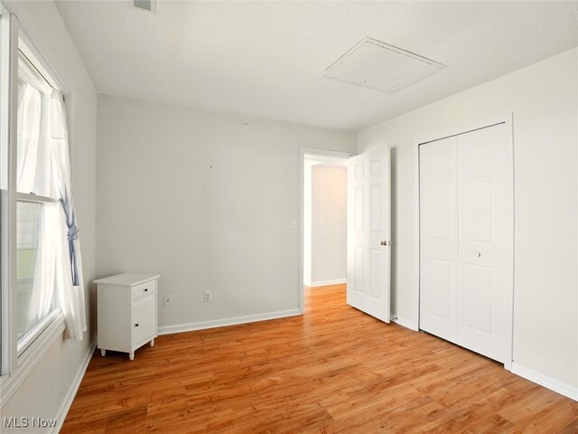 5237 Lake Rd W Unit 1133, Ashtabula, OH 44004 - unfurnished bedroom featuring light wood-type flooring, multiple windows, and a closet