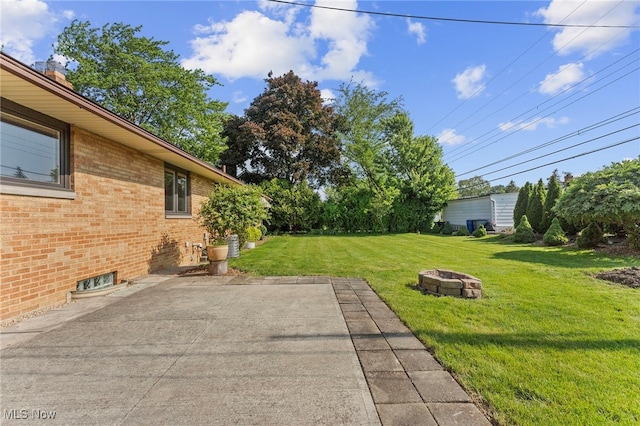 2637 Carmen Dr, Rocky River, OH 44116 - view of grassy yard featuring an outdoor fire pit and a patio area