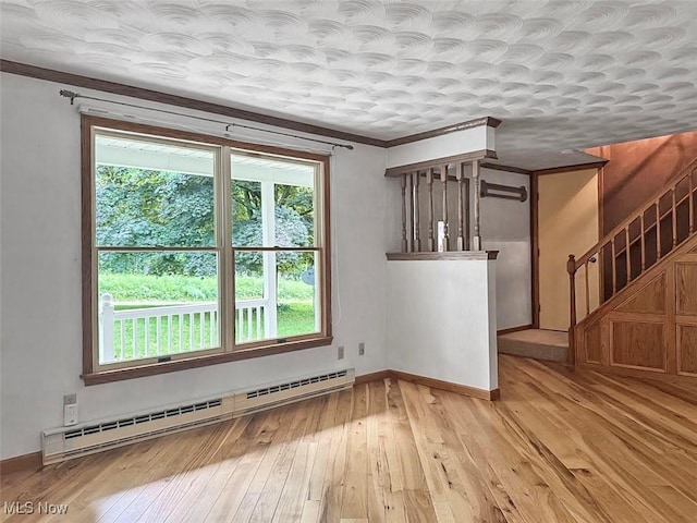 1027 Twp Rd Unit 1806, Ashland, OH 44805 - empty room with a baseboard heating unit, healthy amount of natural light, light wood-style flooring, stairs, and ornamental molding