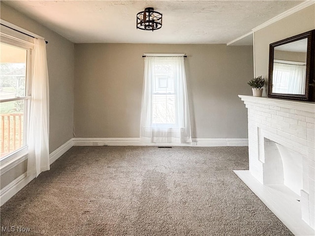 1021 12th Ave, Vienna, WV 26105 - unfurnished living room featuring healthy amount of natural light, carpet flooring, a brick fireplace, and a textured ceiling