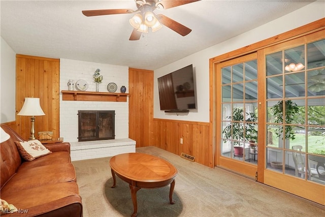 4190 Springdale Rd, Stow, OH 44224 - carpeted living room featuring wood walls, ceiling fan, a fireplace, and a wainscoted wall