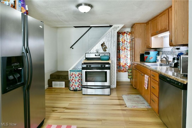 252 E Main St, Newton Falls, OH 44444 - kitchen with stainless steel appliances, light wood-style floors, brown cabinets, and backsplash