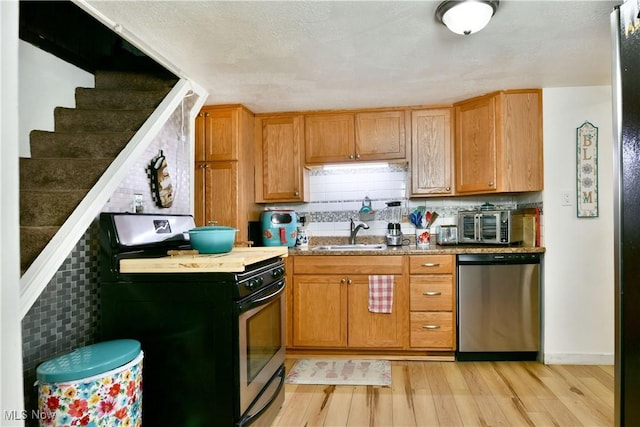 252 E Main St, Newton Falls, OH 44444 - kitchen featuring stainless steel appliances, light wood-style flooring, and decorative backsplash