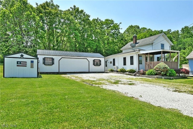 252 E Main St, Newton Falls, OH 44444 - view of front of house featuring an outbuilding, a front lawn, a chimney, and a detached garage