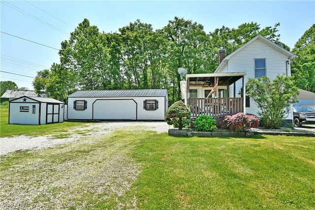 252 E Main St, Newton Falls, OH 44444 - back of property with an outdoor structure, a lawn, a chimney, a garage, and driveway