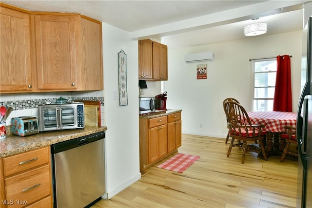 252 E Main St, Newton Falls, OH 44444 - kitchen with appliances with stainless steel finishes, a wall unit AC, light wood-type flooring, tasteful backsplash, and light stone countertops