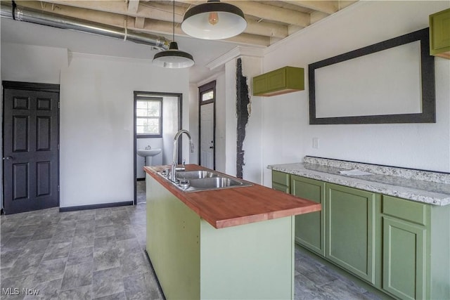 1384 Stark Ave SW, Canton, OH 44706 - kitchen with green cabinets, a center island with sink, hanging light fixtures, and stone finish flooring