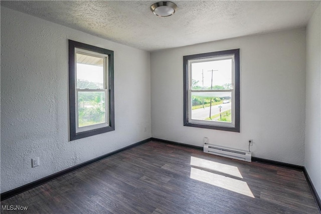 1384 Stark Ave SW, Canton, OH 44706 - spare room with a baseboard heating unit, healthy amount of natural light, wood finished floors, a textured wall, and a textured ceiling