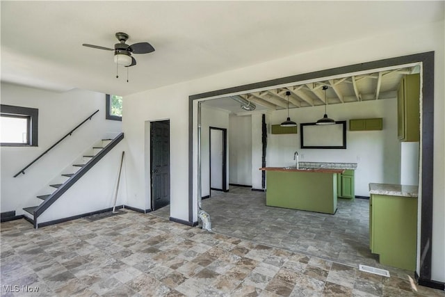 1384 Stark Ave SW, Canton, OH 44706 - unfurnished living room with stone finish flooring, stairs, and a ceiling fan