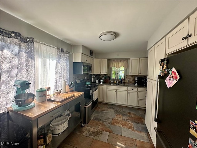 556 Moherman Ave, Youngstown, OH 44509 - kitchen featuring appliances with stainless steel finishes, tasteful backsplash, and stone tile flooring