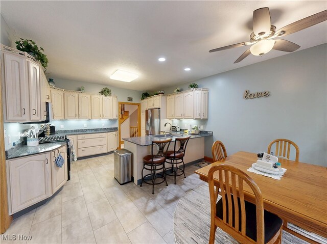 35005 Lisle Ct, Willoughby, OH 44094 - kitchen featuring appliances with stainless steel finishes, a peninsula, dark countertops, ceiling fan, and recessed lighting