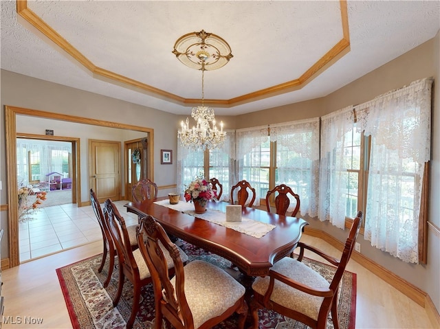 35005 Lisle Ct, Willoughby, OH 44094 - dining room with a tray ceiling, a chandelier, a textured ceiling, and light wood-style flooring
