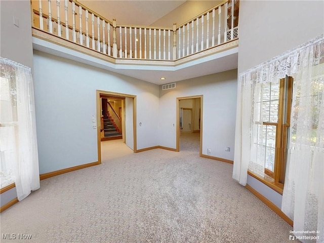 35005 Lisle Ct, Willoughby, OH 44094 - unfurnished living room featuring a towering ceiling, carpet flooring, and stairs