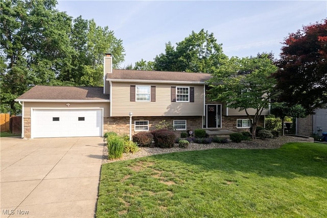 3247 Brooklawn Dr, Norton, OH 44203 - view of front facade with driveway, an attached garage, a chimney, and stone siding