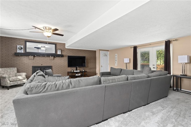 3247 Brooklawn Dr, Norton, OH 44203 - carpeted living area featuring a fireplace, brick wall, a ceiling fan, and a textured ceiling