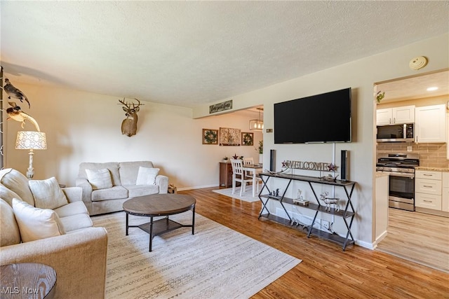 2880 Hetzel Dr, Parma, OH 44134 - living area with light wood finished floors and a textured ceiling