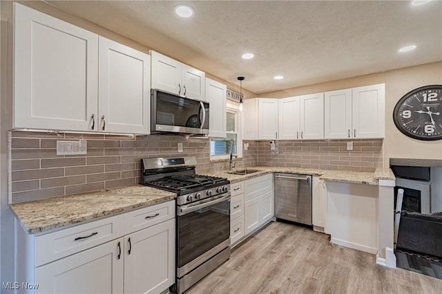 2880 Hetzel Dr, Parma, OH 44134 - kitchen featuring appliances with stainless steel finishes, white cabinets, light wood-style floors, recessed lighting, and light stone countertops