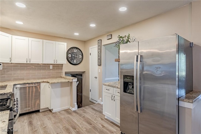 2880 Hetzel Dr, Parma, OH 44134 - kitchen with appliances with stainless steel finishes, light wood-style floors, white cabinets, light stone counters, and recessed lighting