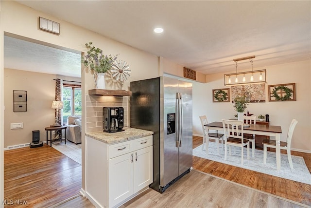 2880 Hetzel Dr, Parma, OH 44134 - kitchen with stainless steel fridge with ice dispenser, light wood-style flooring, white cabinetry, light stone countertops, and recessed lighting